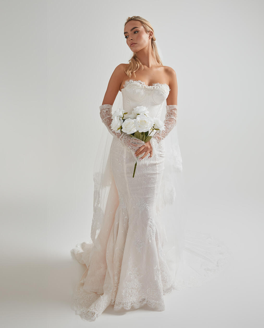 Completed bridal gown with bouquet at AM Bridal Studio Bride wearing her fully tailored wedding gown and holding her bouquet at AM Bridal Studio.