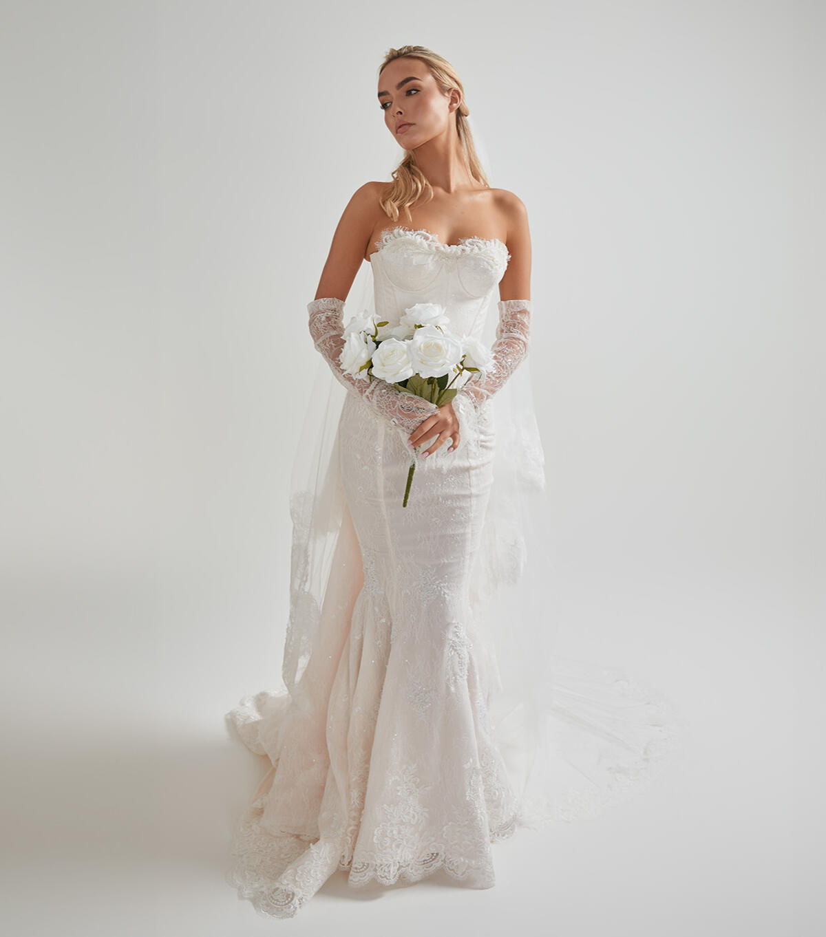 Bride wearing her fully tailored wedding gown and holding her bouquet at AM Bridal Studio.